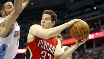 Mar 1, 2015; Denver, CO, USA; New Orleans Pelicans guard Jimmer Fredette (32) looks to pass the ball past Denver Nuggets forward Joffrey Lauvergne (77) during the first half at Pepsi Center. Mandatory Credit: Chris Humphreys-USA TODAY Sports