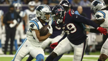 Sep 23, 2021; Houston, Texas, USA; Carolina Panthers running back Chuba Hubbard (30) runs with the ball as Houston Texans defensive end Whitney Mercilus (59) attempts to make a tackle during the fourth quarter at NRG Stadium. Mandatory Credit: Troy Taormina-USA TODAY Sports