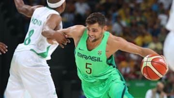 Aug 15, 2016; Rio de Janeiro, Brazil; Brazil guard Raulzinho Neto (5) drives against Nigeria guard Josh Akognon (8) in a men's preliminary round Group B basketball game at Carioca Arena 1 during the Rio 2016 Summer Olympic Games. Mandatory Credit: Jeff Swinger-USA TODAY Sports