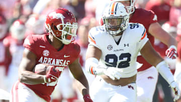 Auburn footballOct 16, 2021; Fayetteville, Arkansas, USA; Arkansas Razorbacks running back Dominique Johnson (20) rushes in the second quarter as Auburn Tigers defensive tackle Marquis Burks (92) defends at Donald W. Reynolds Razorback Stadium. Mandatory Credit: Nelson Chenault-USA TODAY Sports