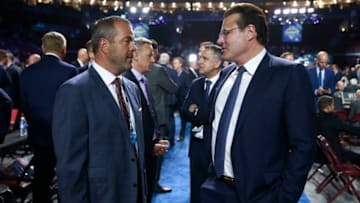 VANCOUVER, BRITISH COLUMBIA - JUNE 21: Head coach Alain Vigneault of the Philadelphia Flyers (L) and owner Francesco Aquilini of the Vancouver Canucks talk on the draft floor during the first round of the 2019 NHL Draft at Rogers Arena on June 21, 2019 in Vancouver, Canada. (Photo by Jeff Vinnick/NHLI via Getty Images)