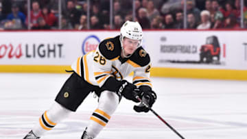 MONTREAL, QC - NOVEMBER 24: Colby Cave #26 of the Boston Bruins reaches for the puck against the Montreal Canadiens during the NHL game at the Bell Centre on November 24, 2018 in Montreal, Quebec, Canada. The Boston Bruins defeated the Montreal Canadiens 3-2. (Photo by Minas Panagiotakis/Getty Images)