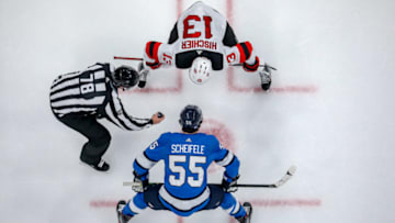 WINNIPEG, MB - NOVEMBER 5: Mark Scheifele #55 of the Winnipeg Jets gets set to take a second period face-off agianst Nico Hischier #13 of the New Jersey Devils at the Bell MTS Place on November 5, 2019 in Winnipeg, Manitoba, Canada. (Photo by Jonathan Kozub/NHLI via Getty Images)