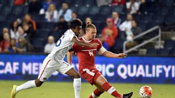 Oct 1, 2015; Kansas City, MO, USA; Canada mid-fielder Sam Piette (14) passes the ball against USA mid-fielder Gedion Zelalem (16) during the first half at Sporting Park. Mandatory Credit: Peter G. Aiken-USA TODAY Sports