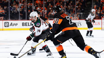 PHILADELPHIA, PENNSYLVANIA - NOVEMBER 02: Shayne Gostisbehere #14 of the Arizona Coyotes skates between Travis Konecny #11 and Rasmus Ristolainen #70 of the Philadelphia Flyers at Wells Fargo Center on November 02, 2021 in Philadelphia, Pennsylvania. (Photo by Tim Nwachukwu/Getty Images)