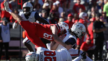 TUCSON, ARIZONA - NOVEMBER 13: Safeties Isaiah Taylor #28 and Dalton Johnson #16 of the Arizona Wildcats collide with punter Michael Williams #61 of the Utah Utes during the fourth quarter of the NCAAF game at Arizona Stadium on November 13, 2021 in Tucson, Arizona. The Utes defeated the Wildcats 38-29. (Photo by Christian Petersen/Getty Images)