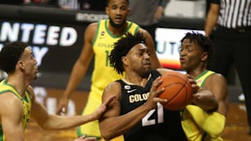 Colorado's Evan Battey, center, battles for position against Oregon during the first half of their game Thursday Feb. 18, 2021.Eug 021821 Uombb Colorado 02