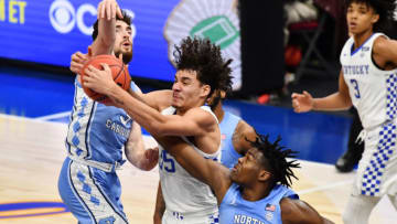 Dec 19, 2020; Cleveland, Ohio, USA; Kentucky Wildcats forward Lance Ware (55) fights for a rebound with North Carolina Tar Heels guard Andrew Platek (3) and forward Day'Ron Sharpe (11) during the second half at Rocket Mortgage FieldHouse. Mandatory Credit: Ken Blaze-USA TODAY Sports