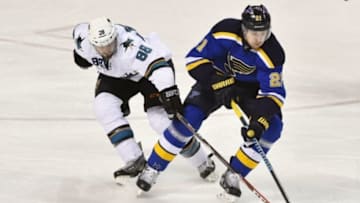 Jan 8, 2015; St. Louis, MO, USA; San Jose Sharks defenseman Brent Burns (88) reaches for the puck on St. Louis Blues center Patrik Berglund (21) during the third period at Scottrade Center. The St. Louis Blues defeat the San Jose Sharks 7-2. Mandatory Credit: Jasen Vinlove-USA TODAY Sports
