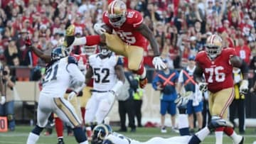December 1, 2013; San Francisco, CA, USA; San Francisco 49ers tight end Vernon Davis (85) jumps over St. Louis Rams cornerback Janoris Jenkins (21) for a touchdown during the fourth quarter at Candlestick Park. The 49ers defeated the Rams 23-13. Mandatory Credit: Kyle Terada-USA TODAY Sports