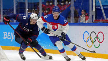 Feb 16, 2022; Beijing, China; Slovakia defender Samuel Knazko (22) moves the puck against United States forward Matt Knies (67) in the men’s ice hockey quarterfinal during the Beijing 2022 Olympic Winter Games at National Indoor Stadium. Mandatory Credit: George Walker IV-USA TODAY Sports