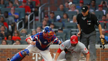 ATLANTA, GEORGIA - AUGUST 02: Jose Peraza #9 of the Cincinnati Reds is called out as he slides across home plate against Tyler Flowers #25 of the Atlanta Braves in the fourth inning at SunTrust Park on August 02, 2019 in Atlanta, Georgia. The Reds challenged the call on the field and it was overturned and Peraza was called safe. (Photo by Kevin C. Cox/Getty Images)