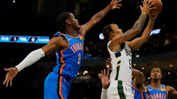 Justin Robinson #55 of the Milwaukee Bucks shoots the ball against Shai Gilgeous-Alexander #2 of the Oklahoma City Thunder in the first half during a preseason game at Fiserv Forum on October 10, 2021 in Milwaukee, Wisconsin. NOTE TO USER: User expressly acknowledges and agrees that, by downloading and or using this photograph, user is consenting to the terms and conditions of the Getty Images License Agreement. (Photo by Patrick McDermott/Getty Images)