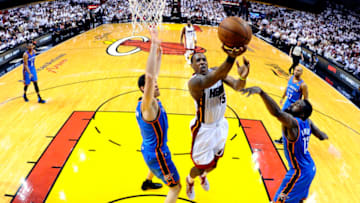 Jun 19 2012; Miami, FL, USA; Miami Heat point guard Mario Chalmers (15)lays the ball up between Oklahoma City Thunder power forward Nick Collison (4) and James Harden (13) during the second half of game four in the 2012 NBA Finals at the American Airlines Arena. Miami won 104-98. Mandatory Credit: Larry W. Smith/Pool Photo via USA TODAY Sports