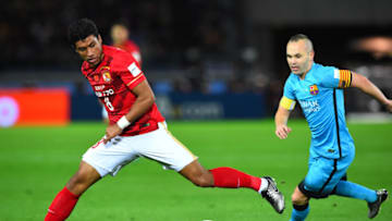 YOKOHAMA, JAPAN - DECEMBER 17: Paulinho of Guangzhou Evergrande FC(L) and Andres Iniesta of Barcelona(R) compete for the ball during the FIFA Club World Cup Semi Final match between Barcelona and Guangzhou Evergrande FC at International Stadium Yokohama on December 17, 2015 in Yokohama, Japan. (Photo by Masterpress/Getty Images)