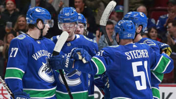 VANCOUVER, BC - FEBRUARY 11: Bo Horvat #53 of the Vancouver Canucks is congratulated by teammates Ben Hutton #27, Elias Pettersson #40, and Troy Stecher #51 after scoring during their NHL game against the San Jose Sharks at Rogers Arena February 11, 2019 in Vancouver, British Columbia, Canada. (Photo by Jeff Vinnick/NHLI via Getty Images)