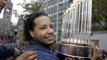 BOSTON - OCTOBER 30: Red Sox World Series MVP Manny Ramirez proudly displays the World Series Championship Trophy to fans on Boylston Street during a rolling rally parade to celebrate his baseball team's World Series win. (Photo by Stan Grossfeld/The Boston Globe via Getty Images)