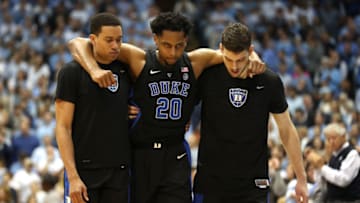 CHAPEL HILL, NORTH CAROLINA - MARCH 09: Marques Bolden #20 of the Duke Blue Devils is helped off the floor by teammates after an injury during their game against the North Carolina Tar Heels at Dean Smith Center on March 09, 2019 in Chapel Hill, North Carolina. (Photo by Streeter Lecka/Getty Images)