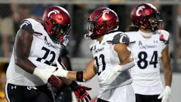 Cincinnati Bearcats running back Ryan Montgomery celebrates with offensive lineman James Tunstall. The Enquirer.