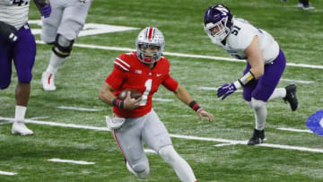 Ohio State Buckeyes quarterback Justin Fields (1) rushes upfield ahead of Northwestern Wildcats linebacker Blake Gallagher (51) during the first quarter of the Big Ten Championship football game at Lucas Oil Stadium in Indianapolis on Saturday, Dec. 19, 2020.Big Ten Championship Ohio State Northwestern