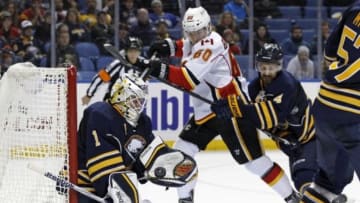 Dec 11, 2014; Buffalo, NY, USA; Buffalo Sabres goalie Jhonas Enroth (1) makes a glove save on a shot as Calgary Flames center Markus Granlund (60) looks for a rebound during the third period at First Niagara Center. Sabres beat the Flames 4-3. Mandatory Credit: Kevin Hoffman-USA TODAY Sports
