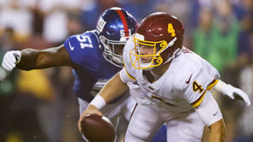 LANDOVER, MARYLAND - SEPTEMBER 16: Taylor Heinicke #4 of the Washington Football Team scrambles from defender Azeez Ojulari #51 of the New York Giants during the first quarter at FedExField on September 16, 2021 in Landover, Maryland. (Photo by Rob Carr/Getty Images)