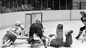 (Original Caption) All eyes are on the puck as Oilers' Wayne Gretzky (9) flips the puck into the net as he falls over Ranger goalie Glen Hanlon and scores the Oilers' first goal in 1st period action at Madison Square Garden 12/14.