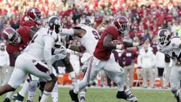 Nov 15, 2014; Tuscaloosa, AL, USA; Alabama Crimson Tide running back T.J. Yeldon (4) carries the ball past Mississippi State Bulldogs linebacker Christian Holmes (44) and Zach Jackson (14) in the second quarter at Bryant-Denny Stadium. Mandatory Credit: Marvin Gentry-USA TODAY Sports