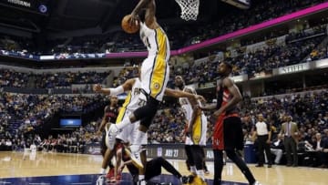 Jan 7, 2014; Indianapolis, IN, USA; Indiana Pacers forward Paul George (24) dunks against Toronto Raptors forward Amir Johnson (15) at Bankers Life Fieldhouse. Indiana defeats Toronto 86-79. Mandatory Credit: Brian Spurlock-USA TODAY Sports