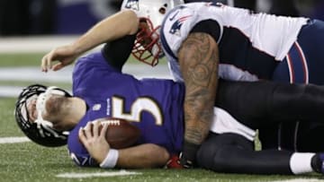 Dec 22, 2013; Baltimore, MD, USA; Baltimore Ravens quarterback Joe Flacco (5) sacked by New England Patriots tackle Seaver Siliga (71) at M&T Bank Stadium. Mandatory Credit: Mitch Stringer-USA TODAY Sports