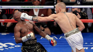 Conor McGregor throws a punch at Floyd Mayweather Jr. during their super welterweight boxing math. (Photo by Sean M. Haffey/Getty Images)