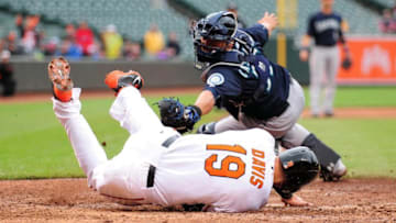 May 21, 2015; Baltimore, MD, USA; Baltimore Orioles first baseman Chris Davis (19) avoids the tag of Seattle Mariners catcher Wellington Castillo (35), to score the go ahead run in the eighth inning at Oriole Park at Camden Yards. Mandatory Credit: Evan Habeeb-USA TODAY Sports