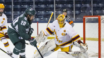 Mar 14, 2021; South Bend, Indiana, USA; Michigan State's Josh Nodler (20) shoots at Minnesota's Jack LaFontaine (45) at the Compton Family Ice Arena. Mandatory Credit: Michael Caterina/South Bend Tribune-USA TODAY NETWORK