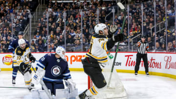WINNIPEG, MB - JANUARY 31: Jake DeBrusk #74 of the Boston Bruins celebrates after scoring a third period goal against goaltender Laurent Brossoit #30 of the Winnipeg Jets at the Bell MTS Place on January 31, 2020 in Winnipeg, Manitoba, Canada. (Photo by Jonathan Kozub/NHLI via Getty Images)
