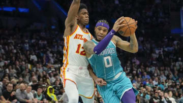 Mar 16, 2022; Charlotte, North Carolina, USA; Charlotte Hornets forward Miles Bridges (0) drives to the basket defended by Atlanta Hawks forward De'Andre Hunter (12) during the second half at the Spectrum Center. Mandatory Credit: Jim Dedmon-USA TODAY Sports