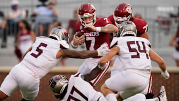 Oklahoma quarterback Spencer Rattler #7 carries against Missouri State defenders Ferrin Manulelua #5), Michael Pope #97 and Von Young #54 in the first half of an NCAA college football game on September 12, 2020, in Norman, Oklahoma. (Photo by Sue Ogrocki-Pool/Getty Images)