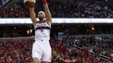 Apr 24, 2015; Washington, DC, USA; Washington Wizards center Marcin Gortat (4) dunks the ball as Toronto Raptors guard Kyle Lowry (7) looks on in the first quarter in game three of the first round of the NBA Playoffs at Verizon Center. Mandatory Credit: Geoff Burke-USA TODAY Sports