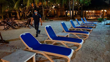 Boracay Island, PHILIPPINES - SEPTEMBER 30: A worker walks past chairs at a resort on September 30, 2020 in Boracay Island, Philippines. The Philippines is reopening Boracay Island, a popular tourist destination known for its resorts and beaches, to more visitors starting October 1 in a bid to revive its pandemic-hit tourism sector. Tourism accounted for almost 13% of the Philippines economic output last year, according to the Department of Tourism. The reopening of Boracay comes as the nation tries to stimulate the economy even as coronavirus cases continue to rise. The country surpassed 312,000 cases of COVID-19, with at least 5,504 deaths. (Photo by Ezra Acayan/Getty Images)