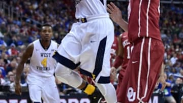 Mar 11, 2016; Kansas City, MO, USA; West Virginia Mountaineers guard Jevon Carter (2) shoots a layup as Oklahoma Sooners forward Ryan Spangler (00) defends in the first half during the Big 12 Conference tournament at Sprint Center. Mandatory Credit: Denny Medley-USA TODAY Sports