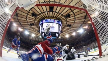 Jun 9, 2014; New York, NY, USA; New York Rangers defenseman Dan Girardi (5) falls over the back of goalie Henrik Lundqvist (rear) and sweeps the puck off the goal line against the Los Angeles Kings during the third period in game three of the 2014 Stanley Cup Final at Madison Square Garden. Mandatory Credit: Bruce Bennett/Pool Photo via USA TODAY Sports