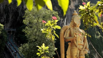 KUALA LUMPUR, MALAYSIA - APRIL 01: Batu Caves is a Hindu shrine and a tourist attraction on April 01, 2010 in Kuala Lumpur, Malaysia. Batu Caves is a limestone hill that has a series of caves and cave temples in the Gombak district, 13 kilometres north of Kuala Lumpur. It takes its name from the Sungai Batu or Batu River, which flows past the hill. Entrance to Batu Caves with the Murugan statue. (Photo by Athanasios Gioumpasis/Getty Images)