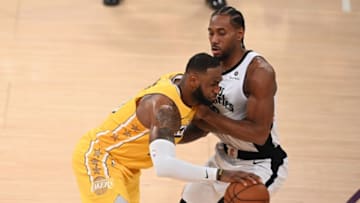 Los Angeles Lakers forward LeBron James (L) drives past Los Angeles Clippers forward Kawhi Leonard (R) during a Christmas Day National Basketball Association (NBA) match-up between the Los Angeles Clippers and Los Angeles Lakers at the Staples Center in Los Angeles, California on December 25, 2019. (Photo by Robyn Beck / AFP) (Photo by ROBYN BECK/AFP via Getty Images)