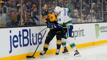Nov 28, 2021; Boston, Massachusetts, USA; Vancouver Canucks center Jason Dickinson (18) checks Boston Bruins defenseman Jakub Zboril (67) with the puck during the second period at TD Garden. Mandatory Credit: Gregory Fisher-USA TODAY Sports