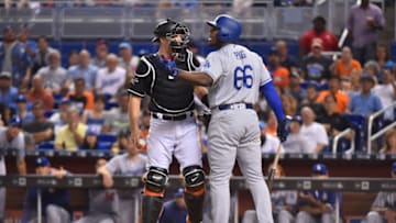 MIAMI, FL - JULY 15: J.T. Realmuto #11 of the Miami Marlins holds back Yasiel Puig #66 of the Los Angeles Dodgers after a close pitch in the first inning at Marlins Park on July 15, 2017 in Miami, Florida. (Photo by Eric Espada/Getty Images)