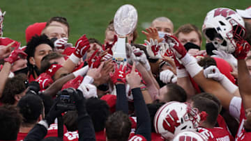 Dec 30, 2020; Charlotte, NC, USA; Wisconsin Badgers hold up the winning trophy after beating Wake Forest at Bank of America Stadium. Mandatory Credit: Jim Dedmon-USA TODAY Sports