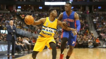 Jan 23, 2016; Denver, CO, USA; Denver Nuggets guard Emmanuel Mudiay (0) handles the ball against Detroit Pistons guard Reggie Jackson (1) during the first half at Pepsi Center. Mandatory Credit: Chris Humphreys-USA TODAY Sports