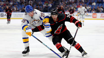 Feb 1, 2023; Buffalo, New York, USA; Buffalo Sabres defenseman Owen Power (25) and Carolina Hurricanes center Seth Jarvis (24) go after a loose puck during the third period at KeyBank Center. Mandatory Credit: Timothy T. Ludwig-USA TODAY Sports