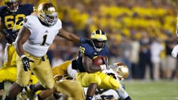 Sep 7, 2013; Ann Arbor, MI, USA; Michigan Wolverines running back Fitzgerald Toussaint (28) runs the ball at Notre Dame Fighting Irish player Louis Nix III (1) in the third quarter at Michigan Stadium. Mandatory Credit: Rick Osentoski-USA TODAY Sports