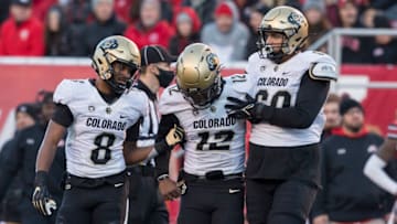 SALT LAKE CITY, UT - NOVEMBER 26: Brandon Lewis #12 of the Colorado Buffaloes is helped back to the huddle by teammates Alex Fontenot #8 and Jake Wiley #60 during their game against the Utah Utes November 26, 2021 at Rice-Eccles Stadium in Salt Lake City , Utah. (Photo by Chris Gardner/Getty Images)