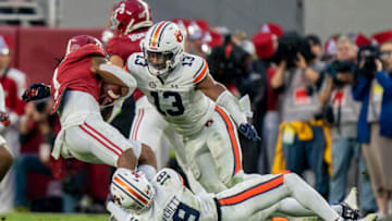 Auburn footballNov 26, 2022; Tuscaloosa, Alabama, USA; Auburn Tigers cornerback Nehemiah Pritchett (18) and Auburn Tigers linebacker Cam Riley (13) tackle Alabama Crimson Tide running back Jahmyr Gibbs (1) during the first half at Bryant-Denny Stadium. Mandatory Credit: Marvin Gentry-USA TODAY Sports